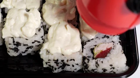 The chef prepares sushi, pouring with sauce, before serving. Stock Footage 325180448