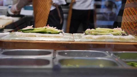 Chef prepares sushi roll in a fast food cafe. 4k, slow-motion shooting Stock Footage 79728923