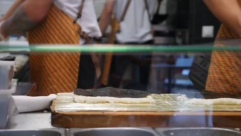 Chef prepares sushi roll in a fast food cafe. 4k, slow-motion shooting Stock Footage