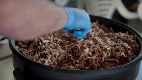Chef preparing and mixing pulled pork or shawarma meat with a fork Stock Footage 314286410