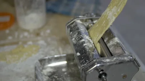 Chef preparing and rolling dough with pasta maker machine at table Stock-Footage 140230411