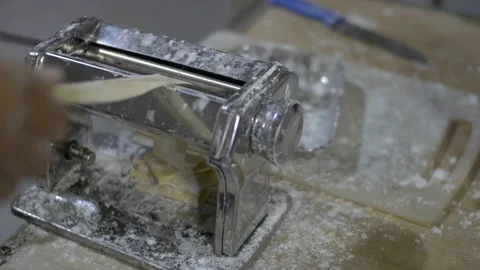 Chef preparing and rolling dough with pasta maker machine at table Stock Footage 140231270