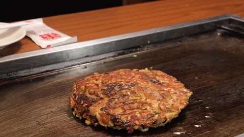 Chef Preparing Authentic Japanese Okonomiyaki Savory Pancake on Hot Teppan Grill Stock Footage 333521399