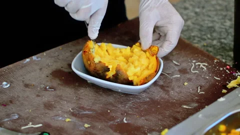 Chef is preparing baked stuffed potato with various ingredients. Stock Footage 152956973