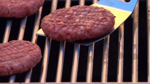 The chef preparing barbecue, putting raw burgers on grill. 4K shot. Vídeo Stock 108617112