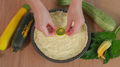 The chef is preparing a beautiful pie with colorful zucchini Stock Footage 264141588