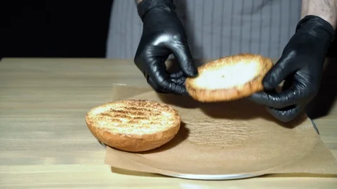 Chef preparing the burger. Cook's hands smearing cream sauce on burger Stock Footage 115839062
