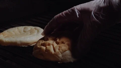 Chef preparing the burger, frying the bun on the grill. Cook turns over the buns Stock Footage 97575837