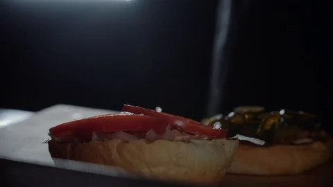 Chef preparing the burger, frying the bun on the grill, adding salt Stock Footage 97576317