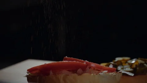 Chef preparing the burger, frying the bun on the grill, adding pepper Stock Footage 97576442