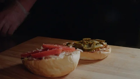 Chef preparing the burger, frying the bun on the grill, putting cutlet Stock Footage 97576480