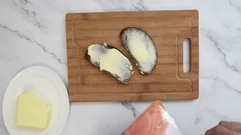 Chef preparing buttered bread and smoked salmon sandwich Stockbeeldmateriaal 317577972