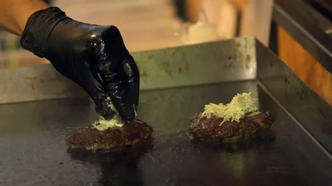 Chef preparing cheeseburger patties on a griddle Video stock 115079072