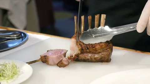 Chef preparing cooked lamb roast. A chef slices roast lamb Vidéo 85422435