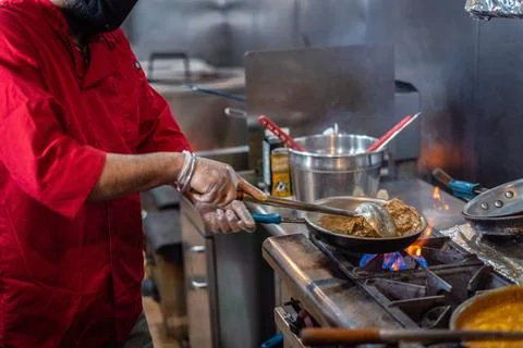 Chef preparing cooking and serving indian cuisine dish Stock Photos