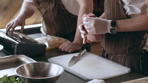 Chef preparing to cut a piece of veal in interior kitchen with soft day lighting Stock Footage 199463783