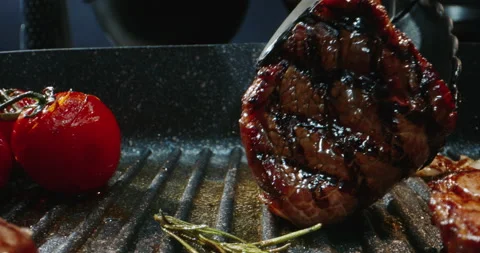 Chef preparing a delicious meal. Cooker frying pieces of juicy beef meat and Stock-Footage 144563221