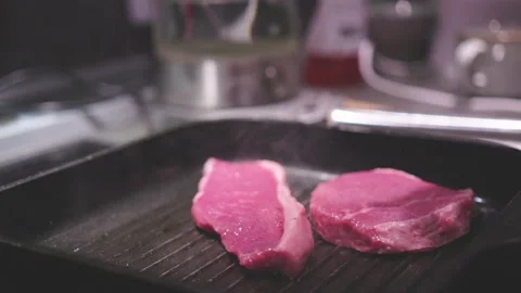 Chef preparing a delicious meal. Cooker frying pieces of juicy beef meat on Stock Footage 235670074