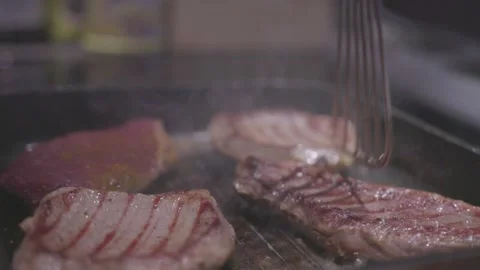 Chef preparing a delicious meal. Cooker frying pieces of juicy beef meat on Stock Footage 235670144