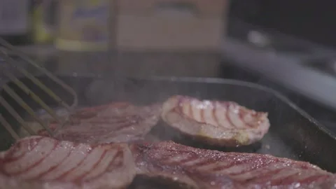 Chef preparing a delicious meal. Cooker frying pieces of juicy beef meat on Stock Footage 235670300