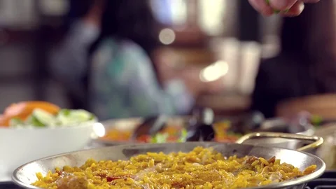 Chef preparing delicious Paella dish adding green peas. Stock Footage 70725927