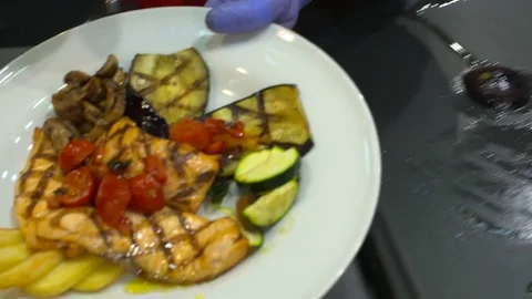 Chef preparing a delicious plate of salmon and vegetables Stock Footage 82610159