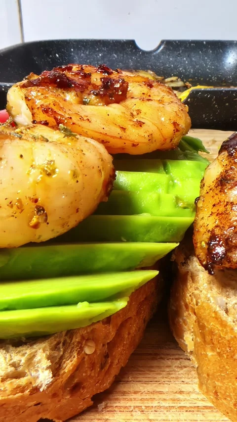 Chef preparing delicious toast with grilled scallops and fresh sliced avocado Video stock 336241420