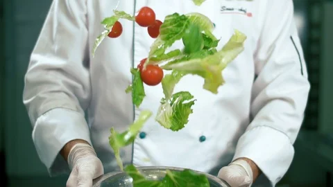 Chef preparing diet salad, throwing up vegetables Stock Footage 102661867