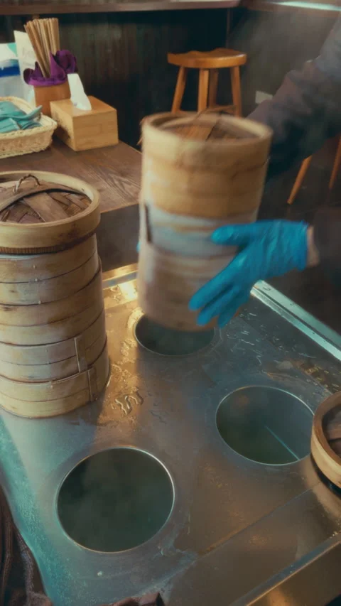 Chef preparing dim sum using bamboo steamers in Wuzhen, China street food market Stock Footage 305659330