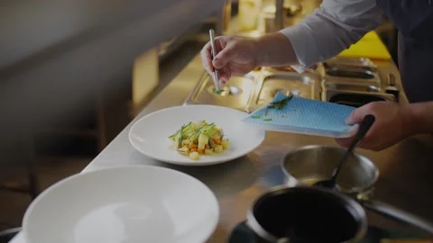 A chef is preparing a dish with a fork and knife Stock Footage 306576941