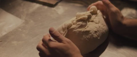 Chef preparing dough with his hands, slowly kneading dough on a metal surface Stock Footage 146923742