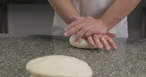 Chef preparing dough for rolling, smashing a piece of dough on a kitchen table Stock Footage 295958241