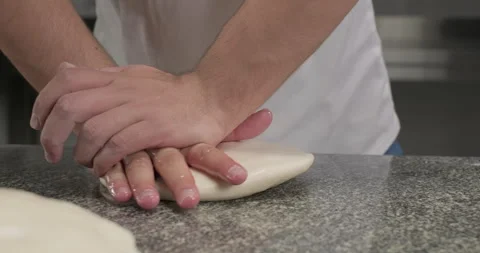 Chef preparing dough, smashing a piece of dough on a kitchen table with oil Stock Footage 294249070