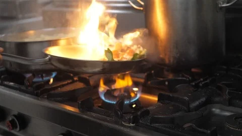 Chef preparing flambe style dish on a frying pan Stock Footage 119391576
