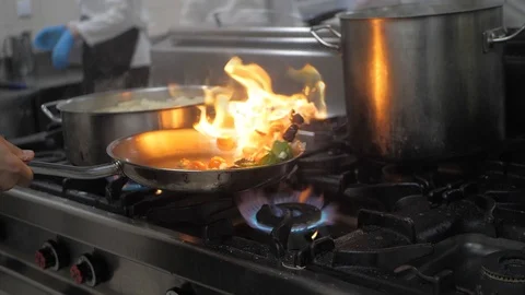 Chef preparing flambe style dish on a frying pan Stock Footage 119391708