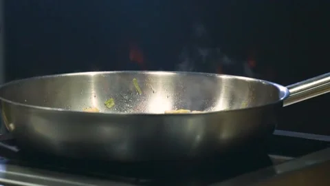Chef Preparing Flambe Style Dish on a Pan. Close-Up Flaming Pan in Slow Motion Stock Footage 150590590