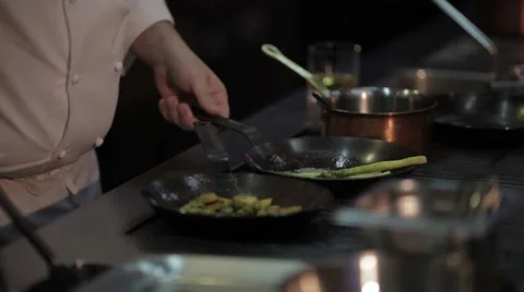 Chef preparing food on the plate , three pans with vegetables . Stock Footage