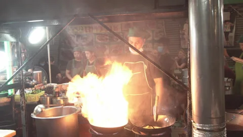 Chef preparing food with stir fry on street. Video stock 136138341