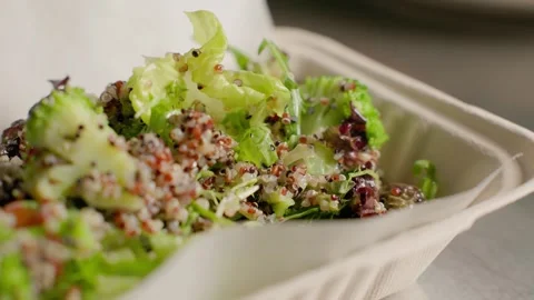 Chef preparing fresh quinoa salad with greens in eco takeout box Stock Footage 312815492