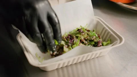 Chef preparing fresh quinoa salad with greens in eco takeout box Stock Footage 312815502