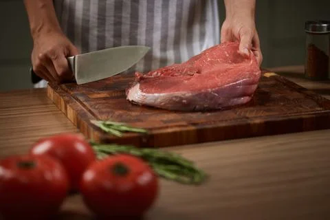 Chef preparing fresh raw beef on cutting board Stock Photos