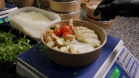 Chef preparing a fresh salad bowl with grilled chicken, cherry tomatoes Stock Footage 340172431