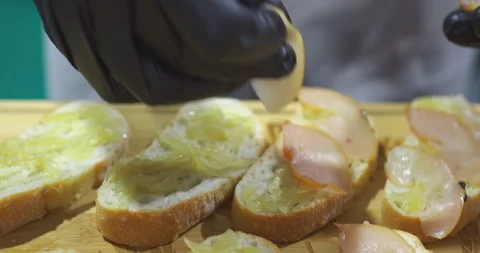 Chef preparing gourmet toasts with gloves in kitchen Stock Footage 302356982