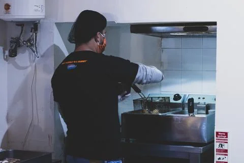 A chef preparing ingredients for some fried american food. Man fried unhealth Foto stock