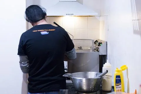 A chef preparing ingredients for some fried american food. Man fried unhealth Stock Photos