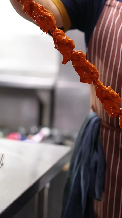 Chef Preparing Marinated Tandoori Chicken on Metal Skewer in Commercial Kitchen Stock Footage 340133970