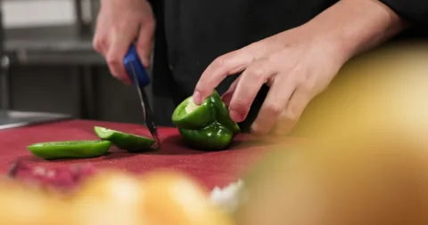 Chef preparing a meal out of vegetables and meat, chopping green bell pepper Stock Footage 290129711