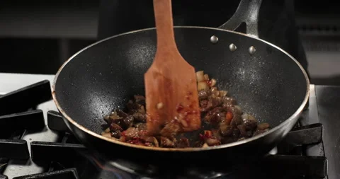 Chef preparing meat and vegetables in a wok pan, stir meat onion and tomato Stock Footage 290288910