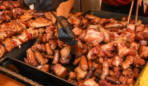 Chef preparing meat on the grill, during outdoor outside food festival, food  Foto stock