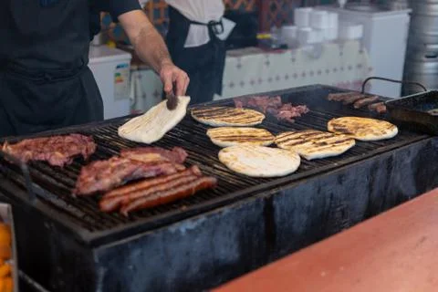 Chef preparing meat on the grill, during outdoor outside food festival Foto stock